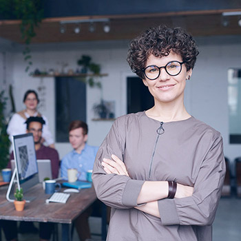Woman posing for camera in office environment with arms crossed